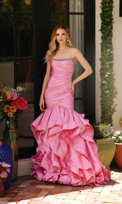 A woman stands outdoors in the Ava Presley 40068 Strapless Ruffled Mermaid Prom Dress, featuring a pleated bodice, beaded trim, and a ruffled mermaid skirt as she poses near a door with potted flowers.