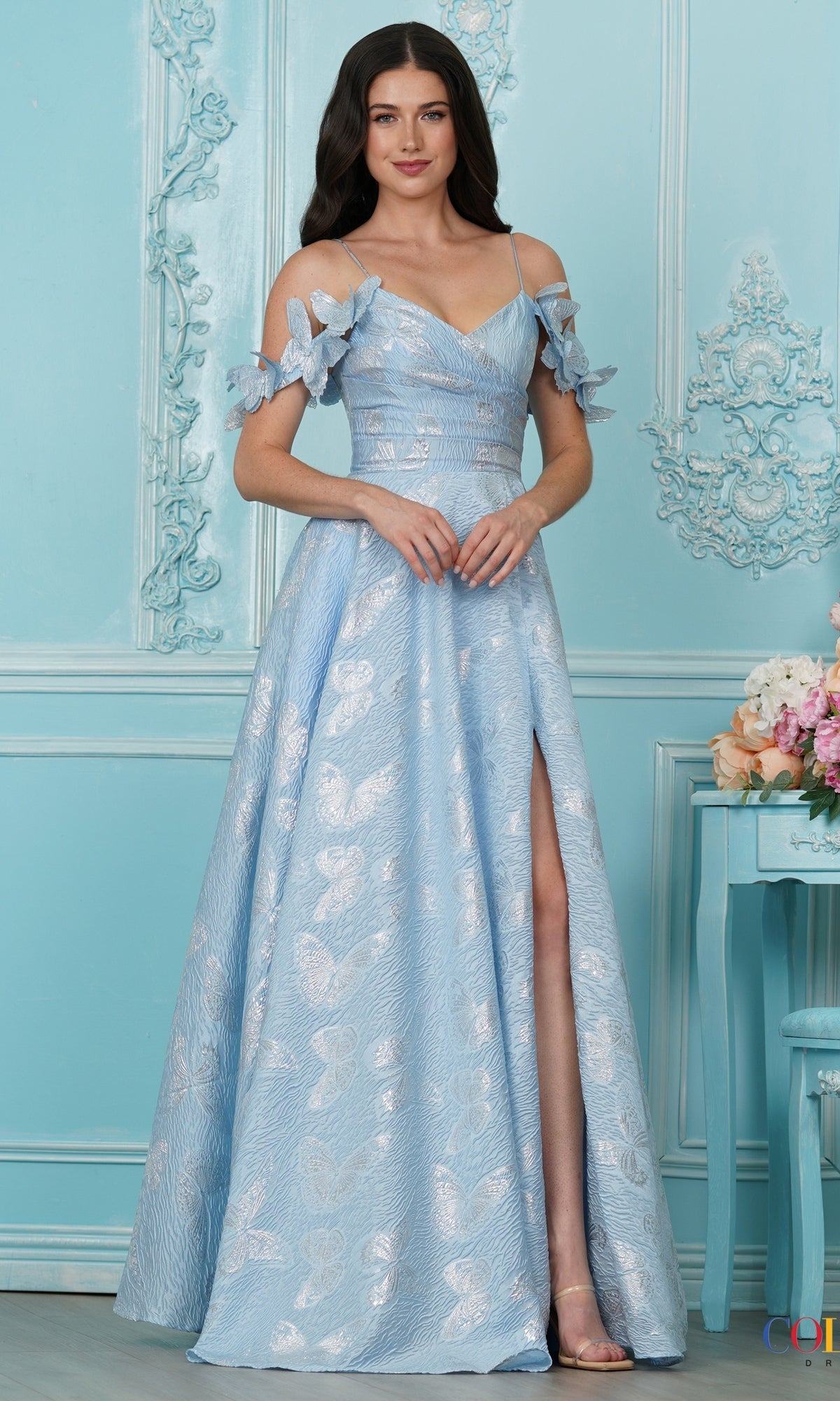 Long Prom Dress: Colors Dress 4010, a blue V-neck dress with a high slit, spaghetti straps, butterfly shoulder accents, and a silvery jacquard butterfly pattern throughout.