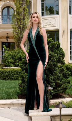 Wearing the Jovani 40119 long prom dress, a woman poses on outdoor steps in front of an elegant building, showcasing its halter velvet style with deep v-neckline and high-leg slit amid beautiful greenery.