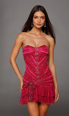 A woman stands against a plain gray background wearing the Short Homecoming Dress: Alyce 40156 in a vibrant raspberry/barbie pink shade. This strapless, fitted mini dress is adorned with sequins and beaded embellishments, and features a stunning layered tulle ruffle hem that adds playful volume and elegant movement to her look.