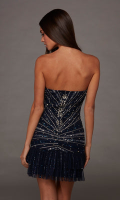 A woman is shown from the back against a plain gray background, wearing the Alyce 40156 Short Homecoming Dress—a strapless mini dress with a dark blue, beaded bodice, a fitted silhouette, and a layered tulle ruffle hem.