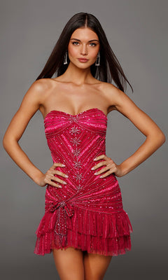 Wearing the Alyce 40156 Short Homecoming Dress, a woman stands against a plain gray background with her hands on her hips. The strapless mini dress is adorned with beaded embellishments and features a layered tulle ruffle hem.