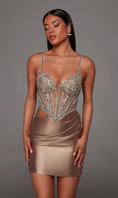 A woman stands against a plain gray background wearing the Alyce 40160 short homecoming dress in mocha, a form-fitting design with spaghetti straps, a beaded corset-style jeweled sheer bodice, and a satin skirt.