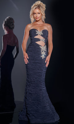 A woman poses in the Jovani 40174 long prom dress, showcasing strapless ruched dark blue fabric with cutouts and gold floral embellishments; her reflection appears in the background.