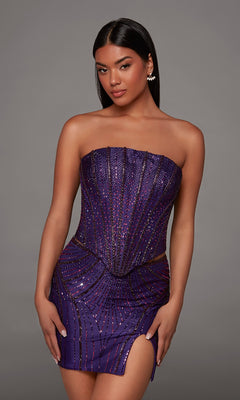 A woman poses in the Alyce 40205 short homecoming dress, a strapless, beaded mini dress in a rich plum shade with a thigh-high slit, set against a plain gray background—embodying the ultimate sparkly cocktail look for an unforgettable night out.
