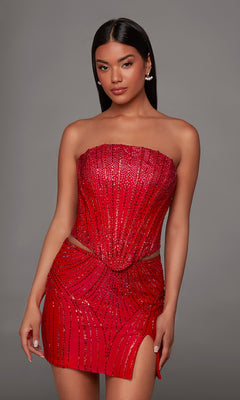 A woman in the Alyce 40205 short homecoming dress—a strapless, sequined red mini with a side slit—stands against a plain gray background.