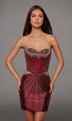 A woman stands against a plain gray background wearing the Alyce 40211 short homecoming dress in vibrant watermelon. The strapless dress features a corset bodice with beaded embellishments and side cutouts that accentuate its fitted silhouette.
