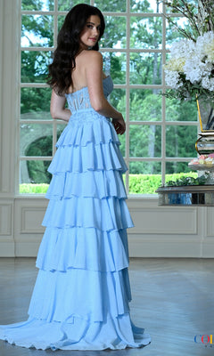 A woman wears a light blue Colors Dress 4022, a strapless floor-length gown featuring a lace bodice and a tiered ruffled skirt.