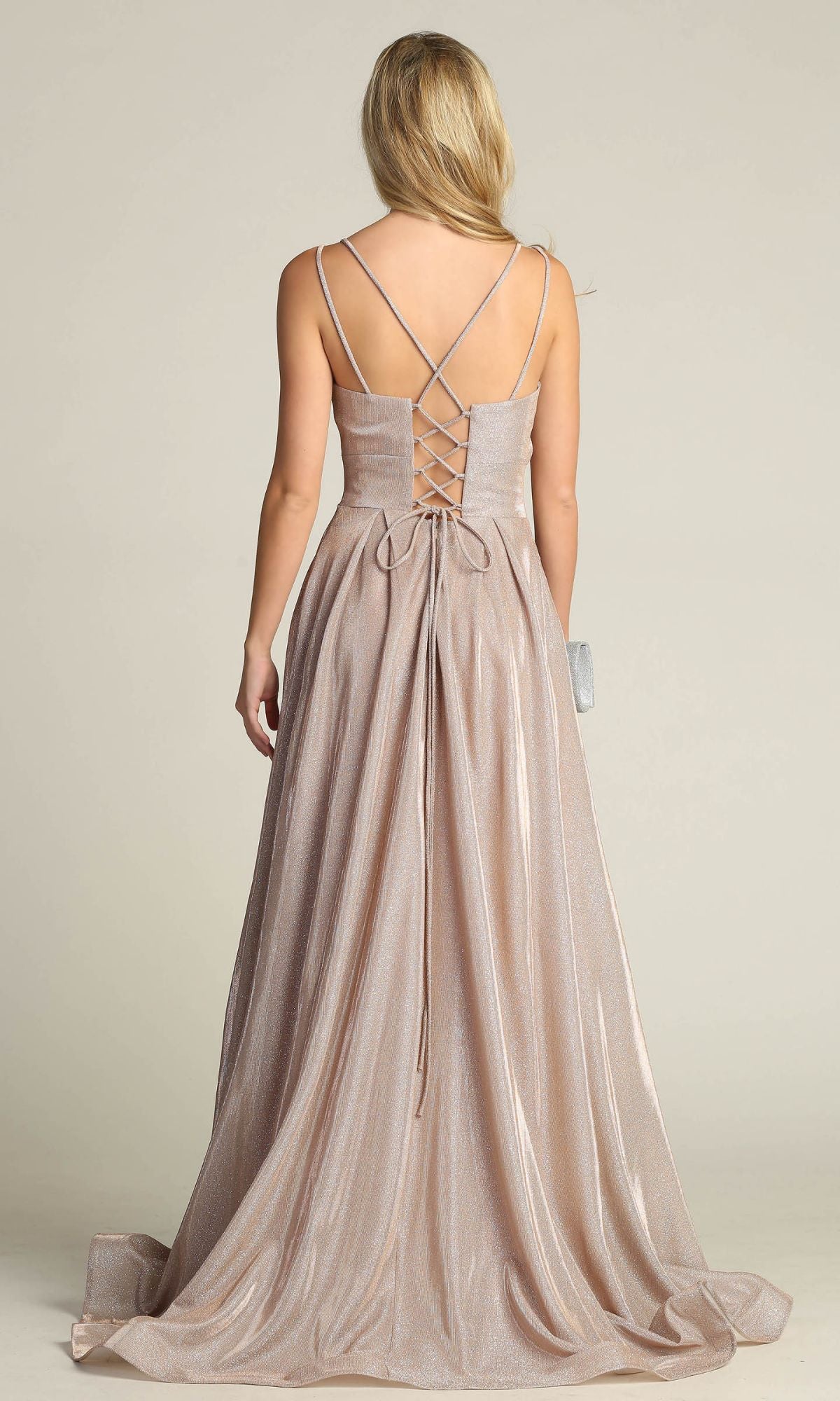 A woman stands with her back to the camera in the Lace-Up Back Long Metallic A-Line Prom Dress 4022, featuring shimmery fabric, thin crisscross straps, and a lace-up corset back.