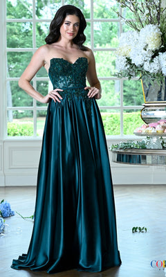 A woman poses in a deep green Long Prom Dress: Colors Dress 4025, featuring a strapless beaded bodice and a floor-length full skirt.