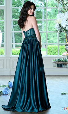 A woman wears a strapless, emerald green floor-length satin Long Prom Dress: Colors Dress 4025 with a corset-style bodice and a full skirt.