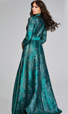 A woman stands with her back turned, modeling the Jovani 40297 long formal dress featuring long sleeves and a textured teal fabric with a subtle metallic sheen, set against a plain light gray background.