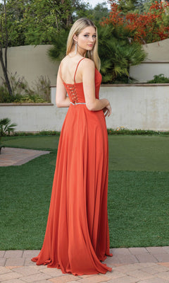 A woman stands outside on grass and pavement, wearing the Simple Long A-Line Prom Dress with Corset Back in orange, looking over her shoulder at the camera.