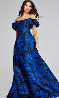 A woman stands elegantly against a plain background wearing the Jovani 40315 long formal dress, an off-the-shoulder ball gown with a blue and black textured pattern.
