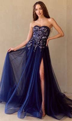 A woman poses elegantly against a beige wall in the Amelia Couture 4031—a strapless navy blue A-line prom gown with floral embroidery, sequin corset bodice, and high slit.