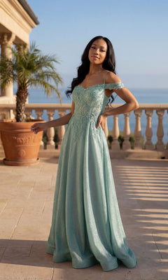A woman in a sage Chicas 4031 long prom dress with an embroidered bodice stands on a terrace featuring a potted palm, stone railing, and an ocean view.