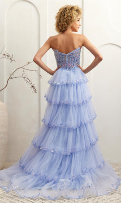 A woman faces away from the camera, wearing the Ruffled Strapless Prom Dress: Amelia Couture 4033 in light blue tulle, with floral embroidery, beading, ruffles, and a sparkling sequin corset bodice.