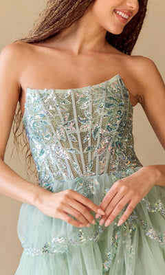 A woman smiles and clasps her hands while wearing the Amelia Couture 4033 Ruffled Strapless Prom Dress, featuring a sequin corset bodice.