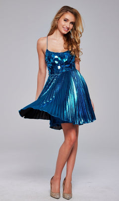 A woman in the Short Metallic Pleated Hoco Dress: Jovani 40350 poses against a neutral background, pairing the shiny blue sleeveless dress with beige high heels.