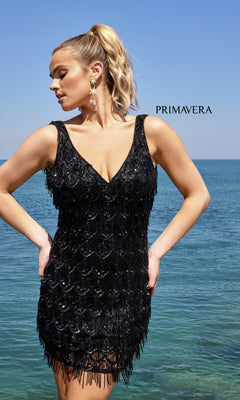 A woman in the Beaded-Fringe Short Semi-Formal Dress 4042 stands by the sea under a clear sky, with "PRIMAVERA" text in the background.