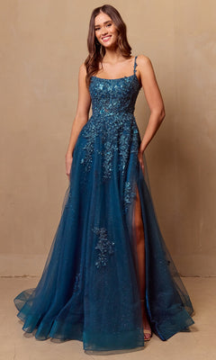 A woman poses against a plain beige background in the Long Corset Prom Ball Gown by Amelia Couture 4044, featuring a sleeveless teal-blue A-line silhouette with floral embellishments and a sheer overlay.
