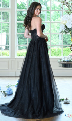 A person wears a Long Prom Dress: Colors Dress 4044 featuring a black corset, strapless bodice, and a sheer, embellished tulle skirt.