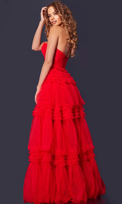 A woman with long curly hair models the Jovani 40466 strapless prom ball gown with a layered tulle skirt, posing against a dark background and looking over her shoulder.