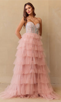 Woman wearing a blush pink tiered dress with a beaded top against a beige background