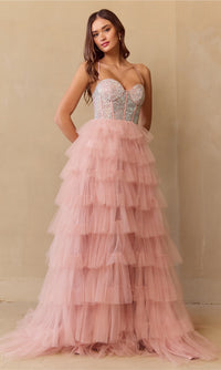 Woman wearing a blush pink tiered dress with a beaded top against a beige background