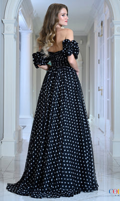 Woman wearing a vintage-inspired, off-the-shoulder black Long Prom Dress: Colors Dress 4053 with white polka dots and puffed sleeves.