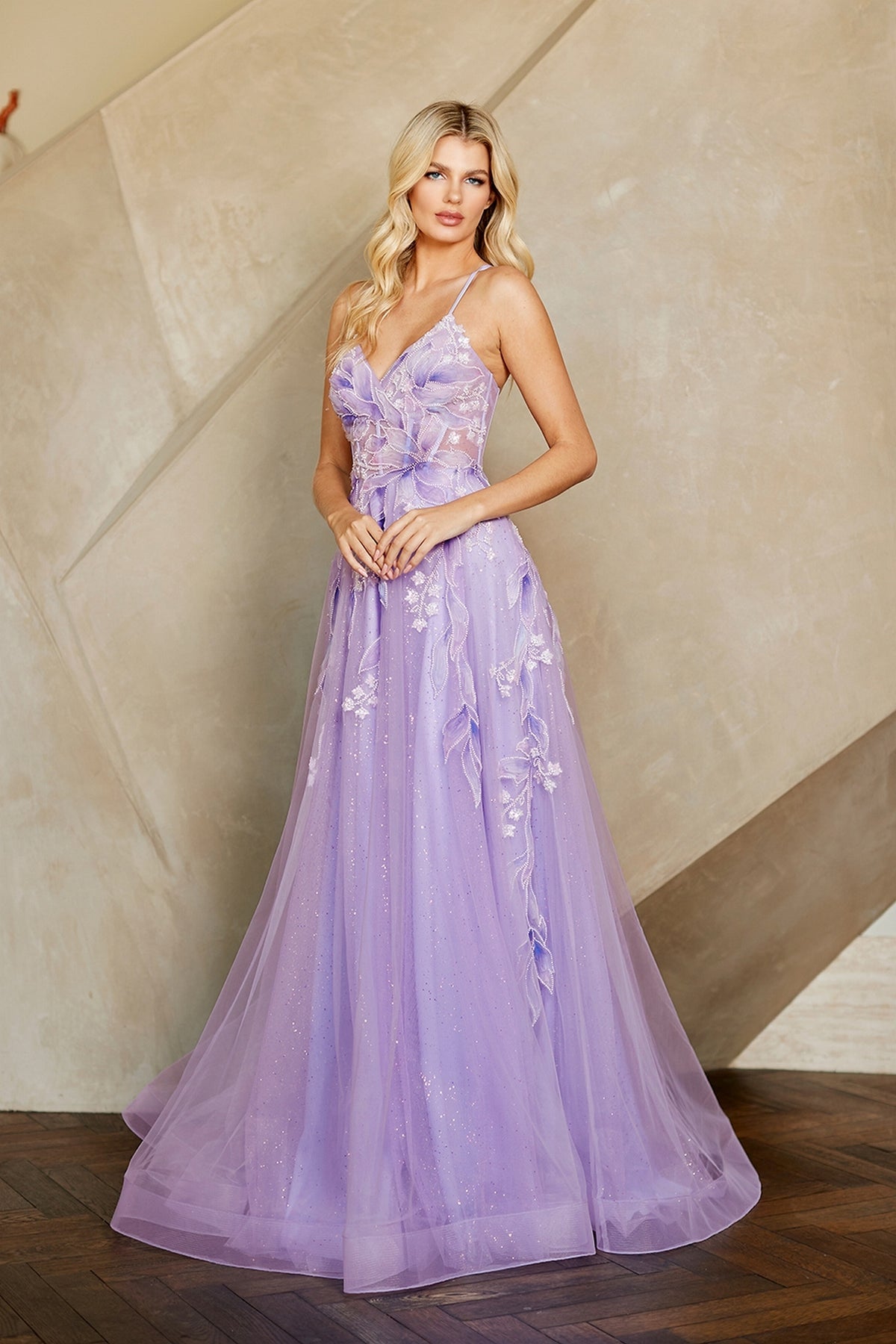 Amelia Couture 4073 is a lilac A-line prom dress with thin straps, a plunging V-neckline, and floral and leaf appliqué details on the bodice and skirt.