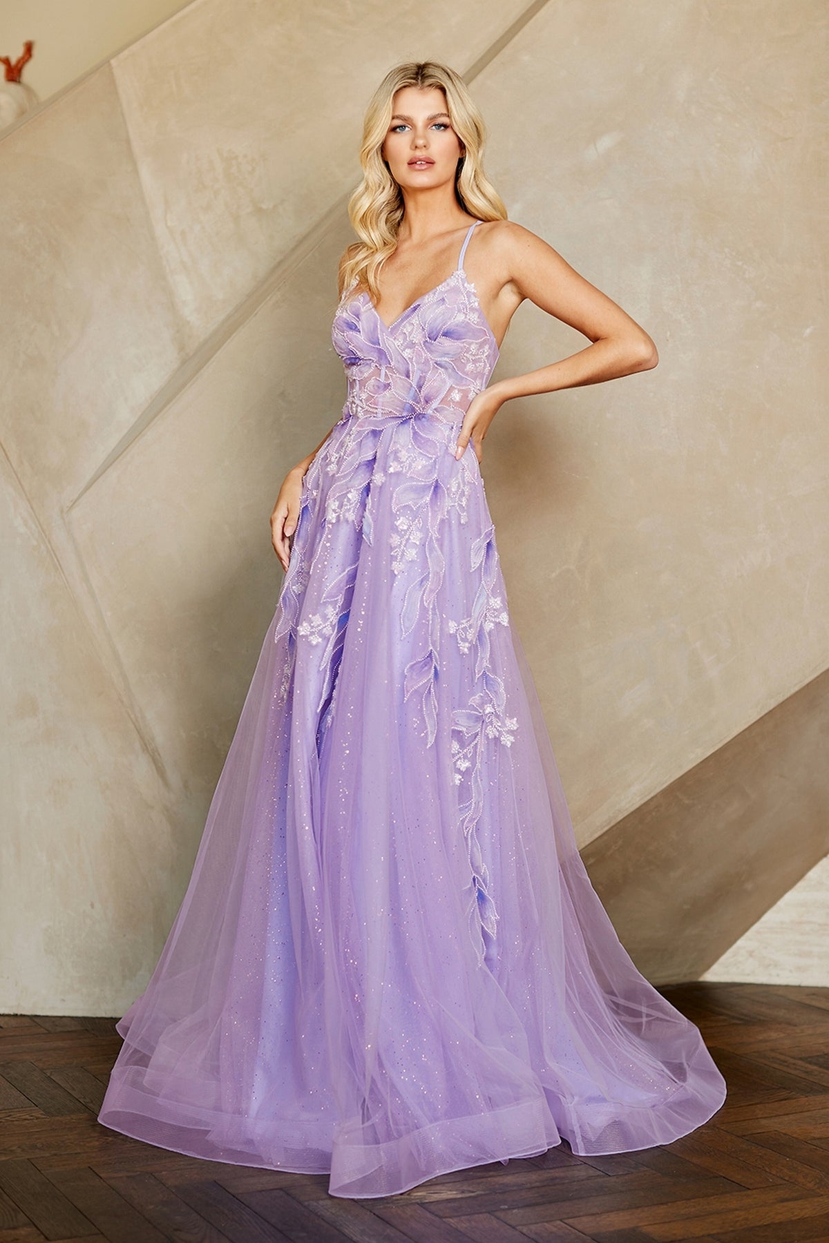Amelia Couture 4073 long lavender A-line evening gown featuring a sheer bodice, spaghetti straps, and floral and leaf appliques overlaying a glitter tulle skirt.