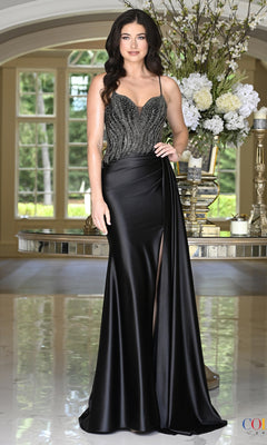 A woman wears a black Colors Dress 4074 floor-length prom dress featuring a beaded, sweetheart neckline bodice and a side leg slit.