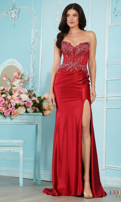 A woman wears a deep red, strapless mermaid Long Prom Dress: Colors Dress 4079 with a beaded bodice, ruched detailing, and a high leg slit.