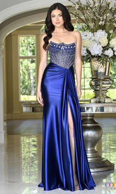 A woman wears a floor-length, deep blueberry Colors Dress 4080 corset prom dress featuring a crystal-embellished bodice and a side slit.