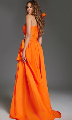A woman wearing the Jovani 40929 long, strapless orange prom dress poses against a plain gray background, looking over her shoulder with a smile.