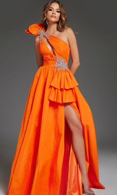 A woman stands against a gray background wearing the Jovani 40929 long prom dress, featuring bright orange color, a one-shoulder neckline, ruffles, jeweled embellishments, and a thigh-high slit.