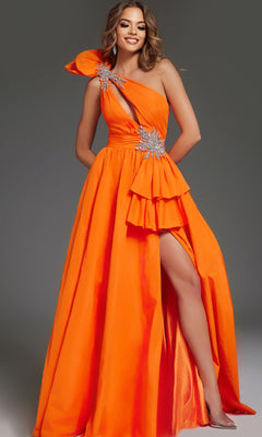 A woman models the Jovani 40929 long prom dress in bright orange, featuring a one-shoulder neckline, embellished details, and a thigh-high slit, standing against a plain gray background.
