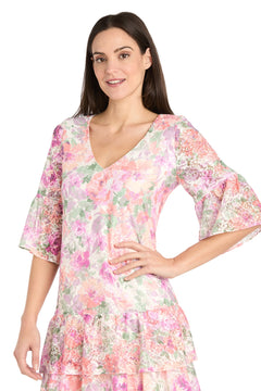 Woman wearing the Short Ivory Floral Party Dress: R&M Richards 4107 with pastel floral print, flared sleeves, and a V-neckline—perfect for a chic casual cocktail dress look.