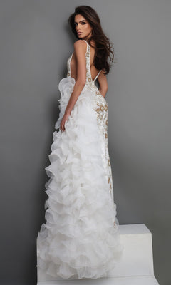 A woman wearing the Jovani 41146 long formal dress—an elegant, floor-length white designer gown featuring ruffled layers on the back and intricate gold detailing—stands on a white platform against a gray backdrop.