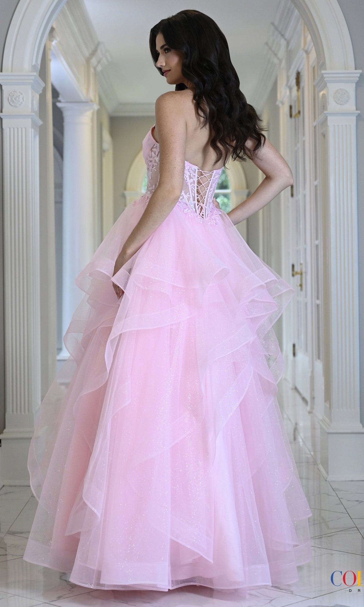 Long Prom Dress: Colors Dress 4151, a floor-length pink ball gown featuring a lace-up corset back and a tiered, ruffled skirt.