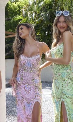 Two women stand outdoors in Primavera 4156 beaded-print designer prom dresses with pastel patterns and thigh-high slits; one wears pink and holds a purse, the other wears green with sunglasses on her head.
