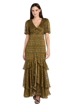 A woman wears the R&M Richards 4157 Long Plaid Wedding Guest Dress, featuring an olive green and brown pattern, short puff sleeves, V-neckline, and tiered ruffle hem, standing against a white background.