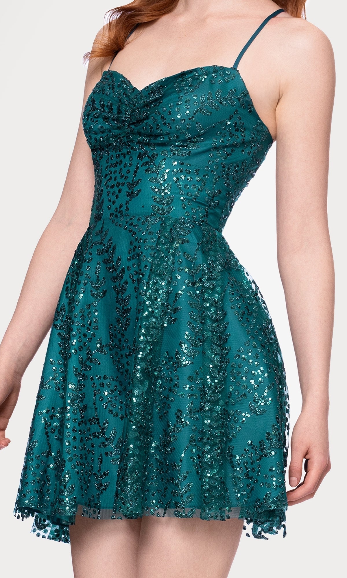 A woman wears the Short Teal Glitter Hoco Dress: Blondie Nites 4159BN, featuring thin straps, a sleeveless design, and a flared skirt.