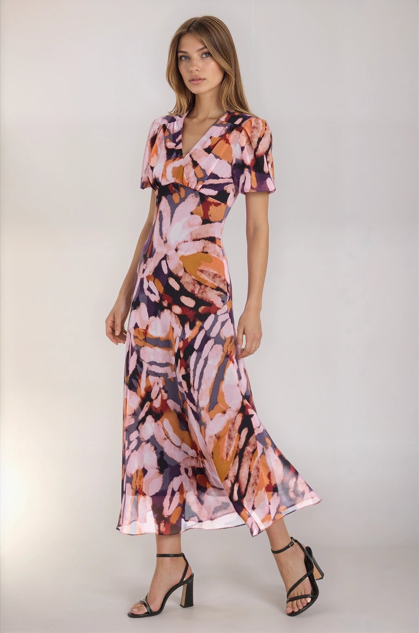 Woman wearing a colorful dress with abstract patterns on a white background