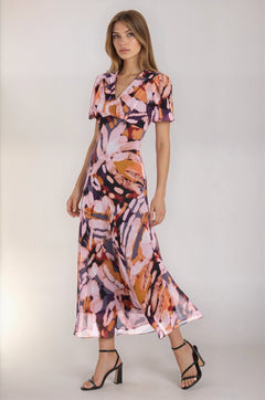 Woman wearing a colorful dress with abstract patterns on a white background