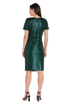 A woman stands with her back to the camera, wearing the R&M Richards 4177 Short Metallic Cocktail Dress in green and black heeled sandals against a white background.