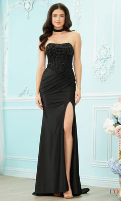 A woman wears a black, strapless, floor-length Colors Dress 4187 corset prom dress featuring a beaded bodice and a high side slit.