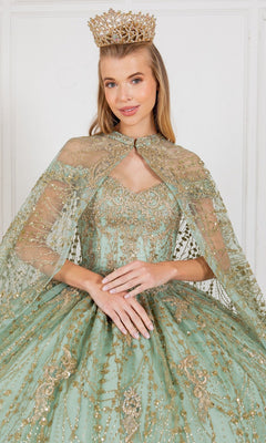A woman wearing a gold crown and the Quinceanera Dress 4201 by Cinderella Couture—an ornate light green ball gown with gold embellishments—stands against a plain white background.