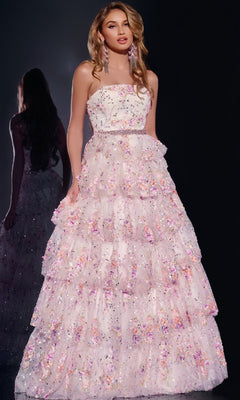 A woman wears the Jovani 42190 Long Prom Dress—a strapless gown with a tiered skirt, beaded waistline, and pastel floral lace with shimmering sequins on a dark background. Her reflection appears behind her.